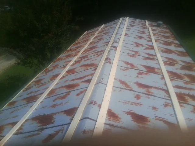 Rusted metal roof panels with new wood purlins before replacement — Storm Damage Roof Repair in Holley by Roofing Brothers