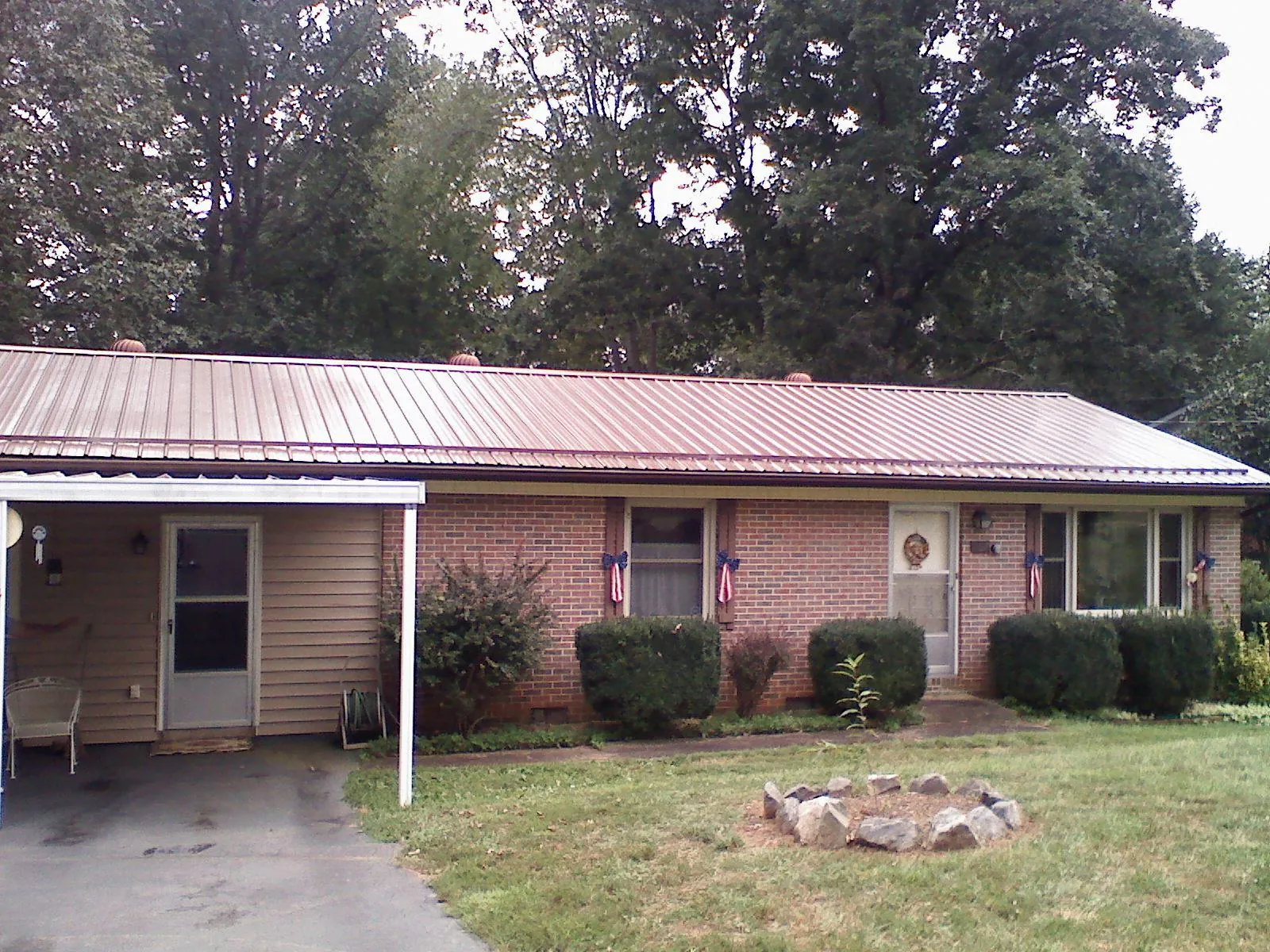 Bronze metal roof and carport on a brick ranch home — Roof Repair work by our crew in Holley