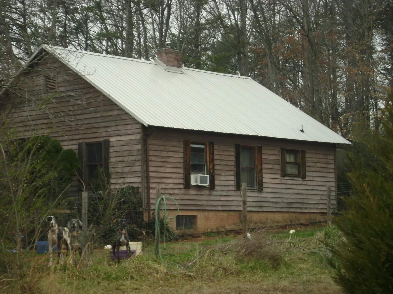White metal roof on an old wood sided farmhouse, from a Metal Roof Installation job in Holley